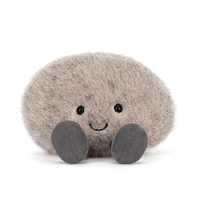 Plush toy resembling a round grey pebble with a smiling face on a white background