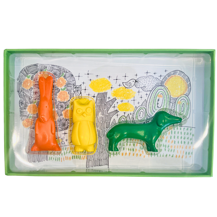 A set of three animal-shaped crayons in orange, yellow, and green, displayed in a clear packaging with illustrated animals and patterns on the inside.