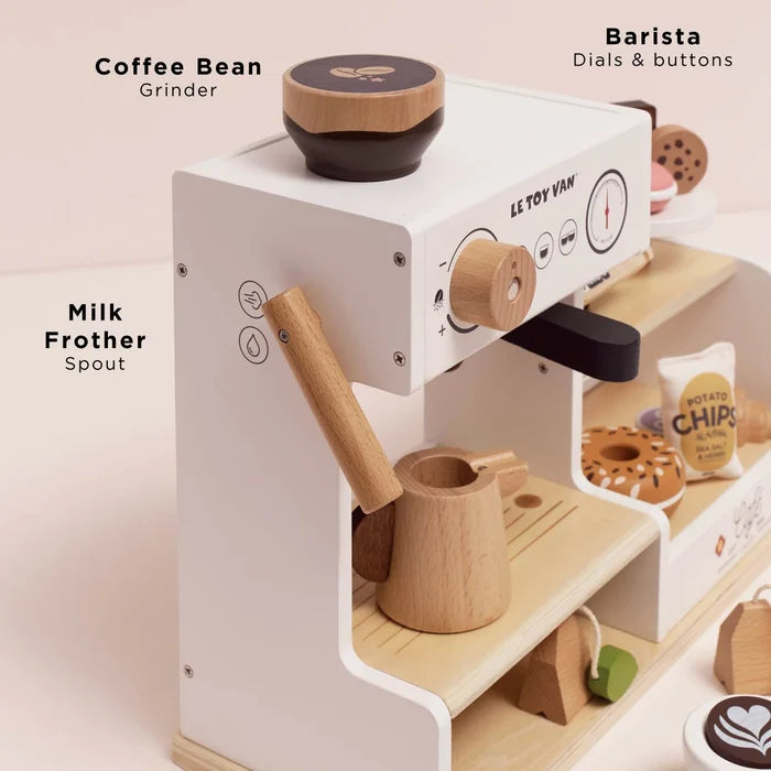 Wooden toy coffee machine with labeled parts on a light background