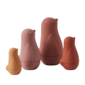 A set of four Chickadee Nesting Dolls in shades of pink and brown, stacked in size order with the smallest on the bottom and the largest on top.