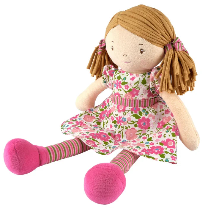 Toy doll with a floral dress and pink shoes on a white background
