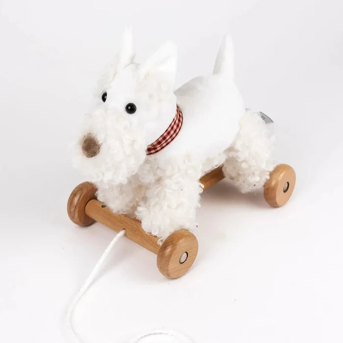 White plush dog toy with wooden wheels on a white background