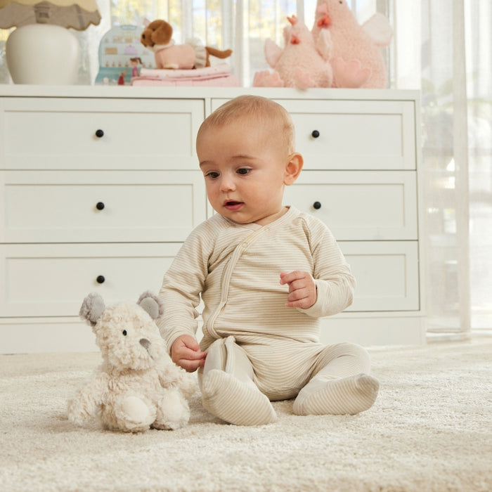 Baby in a white room with toys and furniture