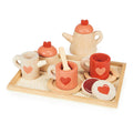 A wooden tea set toy on a tray, including a teapot, cups with saucers, spoons, a sugar pot with lid, a milk jug, and biscuits.